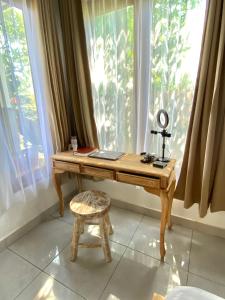 a desk in front of a window with a camera at Bali Bakas House II in Banjarangkan