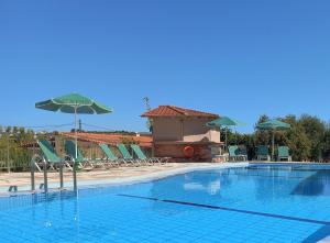 a large swimming pool with chairs and umbrellas at Family Friendly Kalliopi Apt in Kavros