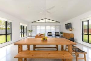 a dining room and living room with a wooden table at Eleven Watson Guesthouse in Mossman +39 photos