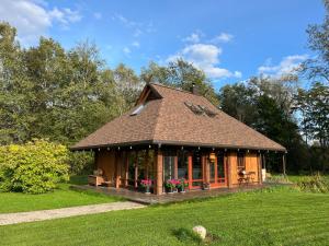 a small house in the middle of a field at UpeNes in Lubāna