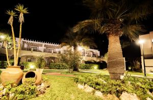 a palm tree in front of a building at night at Ona Village Cala d'Or in Cala d´Or