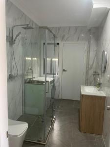 a bathroom with a shower and a toilet and a sink at Quiet Spacious Family House 11 Bedrooms in Colyton