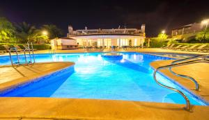 a large swimming pool with blue water at night at Ona Village Cala d'Or in Cala d´Or