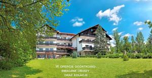 budynek z zielonym trawnikiem przed nim w obiekcie Villa Medica w Rabce