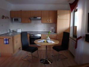 eine kleine Küche mit einem Tisch und 2 Stühlen in der Unterkunft Apartment Pahl in Wolfshagen