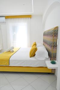 a bedroom with a bed with yellow and white pillows at Gala Residence Villa Giovanna in Ravello