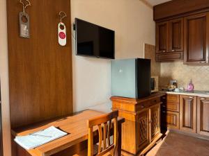 a kitchen with a wooden table with a television on it at EURO HOUSE INN airport in Fiumicino