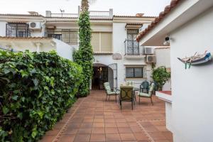 einen Innenhof in einem Haus mit Stühlen und Pflanzen in der Unterkunft Casa en Guadalmar Malaga, Naturaleza y Playa in Málaga