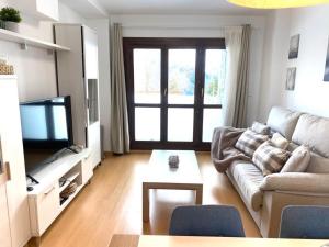 a living room with a couch and a tv at Chalet pareado para familias in Formigal +9 photos