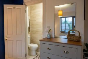 a bathroom with a toilet and a sink and a mirror at Modern Top Floor Apartment in Watford
