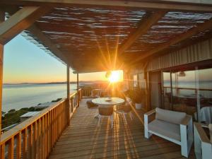 a balcony with a table and chairs and the sunset at Sea View Amazing in Saint-Raphaël