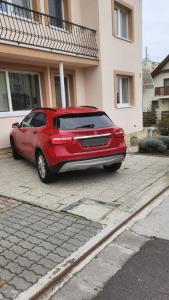 a red car parked in front of a house at Apartman Kováčová in Kováčová