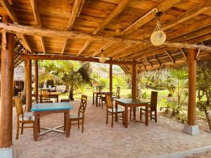 a wooden pergola with tables and chairs on a patio at Villa LA Kurumba in Ambalangoda