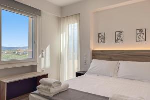 a bedroom with a large bed and a window at AéNaos Luxury Villa with Pool in Galatas in Galatás +44 photos