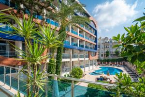 アランヤにあるGardenia Hotelのヤシの木が茂るアパートメントビル