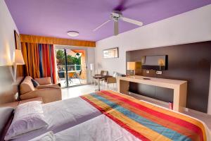 Un dormitorio con una cama grande con una manta colorida. en SBH Monica Beach Resort, en Costa Calma