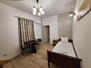 a bedroom with a bed and a table and chairs at Vila Ris Piata Romana in Bucharest