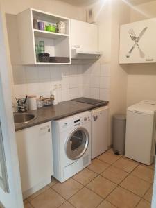 a kitchen with a washing machine and a sink at L' Appartement du Quai Neuf Parking privé - Gare à 5min in Béziers