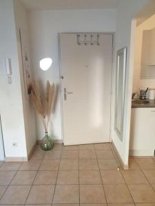 a kitchen with a white door and a tile floor at L' Appartement du Quai Neuf Parking privé - Gare à 5min in Béziers +3 photos