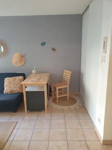 a living room with a table and a chair at L' Appartement du Quai Neuf Parking privé - Gare à 5min in Béziers