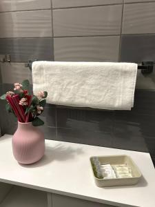 a bathroom with a vase of flowers and a towel at La Casa di Pablo B&B in Ferrara