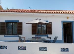 a table with an umbrella in front of a house at Country House Silves in Silves +8 photos