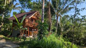 テテバトゥにあるVilla Lunaのヤシの木が茂る森の木造家屋
