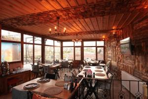 a dining room with tables and chairs and windows at Rose Valley Hotel in Göreme