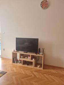 a flat screen tv on a wooden stand in a living room at Apartment California in Brčko
