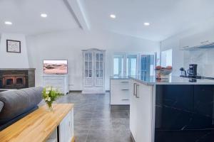 a kitchen with white cabinets and a couch in a room at Casa al Mar in Maspalomas