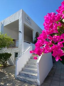 a building with a staircase with pink flowers at Lindos Athena in Lindos