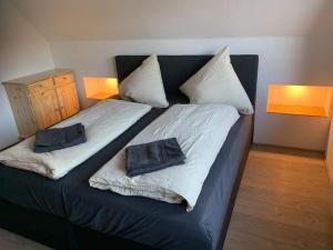a bed with two pillows on it in a room at Jermerstein-Häuschen in Braunlage