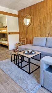 a living room with a couch and a coffee table at Studio central proche des pistes in Isola