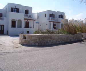 a building with a stone wall in front of a street at Roussos Beach Hotel in Naousa