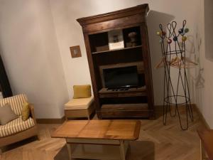 a living room with a tv and a coffee table at Charmant appartement sur cour, Le Cerisier in Bagnères-de-Bigorre