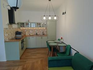 a kitchen and dining room with a table and green chairs at Oława Jodłowa in Oława