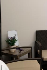 a table with a plant on it next to two chairs at Dea Suite in Bagheria +54 photos