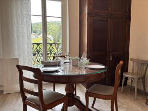 a dining room table with wine glasses on it at Le 130 - 1 chambre - Wifi - Proche Parc Thermal - 2 personnes in Châtel-Guyon +5 photos