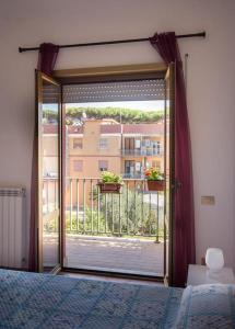 a bedroom with a door open to a balcony at Dragonfly apartment in Acilia