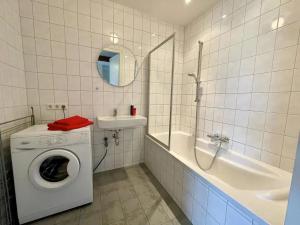 y baño blanco con lavadora y bañera. en Huis aan de vijver, en Kamperland 44 fotos más