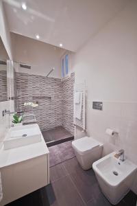フィレンツェにあるApartments Florence Borgo dei Greciの白いバスルーム(洗面台2台、トイレ付)