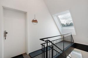 un escalier avec une rampe noire à côté d'une fenêtre dans l'établissement Ferienwohnung Maurer, à Königsfeld im Schwarzwald 22 autres photos