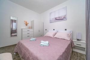 a bedroom with a pink bed with two towels on it at House Diana in Pučišća +37 photos