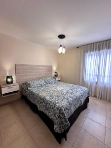 a bedroom with a large bed and a window at Departamento Premium, Paseo Buen Pastor in Cordoba