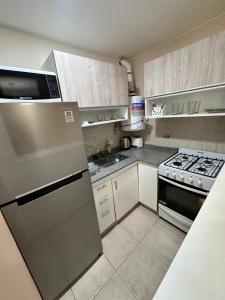 a kitchen with a refrigerator and a stove at Departamento Premium, Paseo Buen Pastor in Cordoba