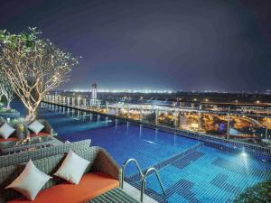 a pool on the roof of a building at night at Ibis Saigon Airport in Ho Chi Minh City