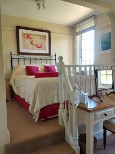 a bedroom with a bed with red pillows at Rock House Cottage in Exeter