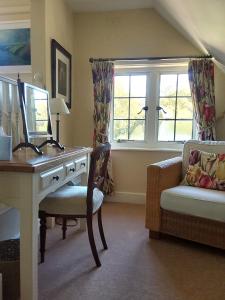 a room with a desk and a chair and a window at Rock House Cottage in Exeter