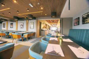 a restaurant with blue booths and tables and chairs at Lumière Hotel Pool & SPA in Belgrade