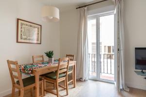 a dining room with a table and chairs and a television at Sweet Home Santander in Santander